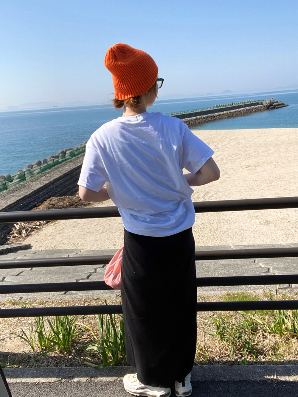 ホワイト系のTシャツ/カットソー、ブラック系のスカート、ホワイト系のスニーカーを着用したレディースの春コーディネートの3枚目の写真