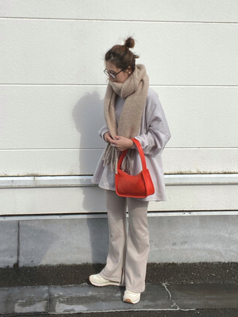 グレー系のスウェット、グレー系のその他パンツ、オレンジ系のショルダーバッグを着用したレディースの秋コーディネートの3枚目の写真