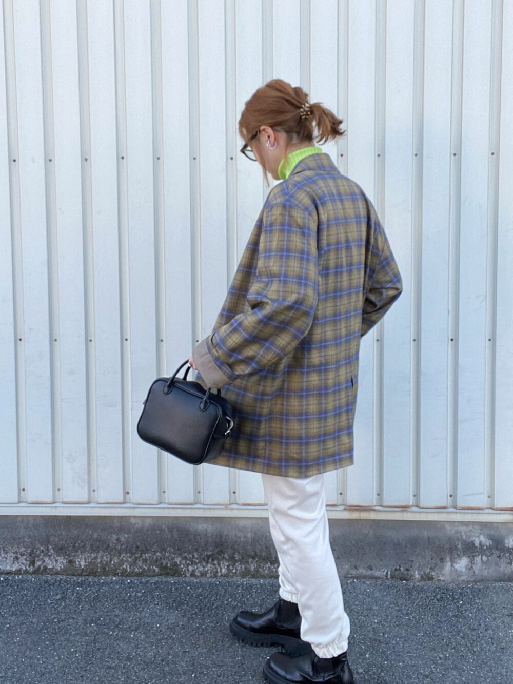 イエロー系のテーラードジャケット、ブラック系のボストンバッグ、ブラック系のブーツを着用したレディースの冬コーディネートの3枚目の写真