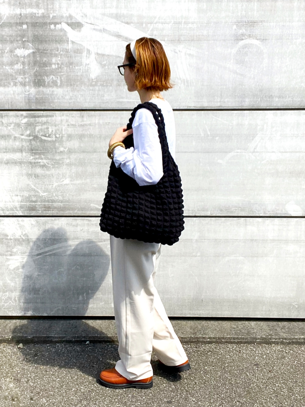 ホワイト系のTシャツ/カットソー、ホワイト系のスラックス、イエロー系のローファーを着用したレディースの秋コーディネートの2枚目の写真