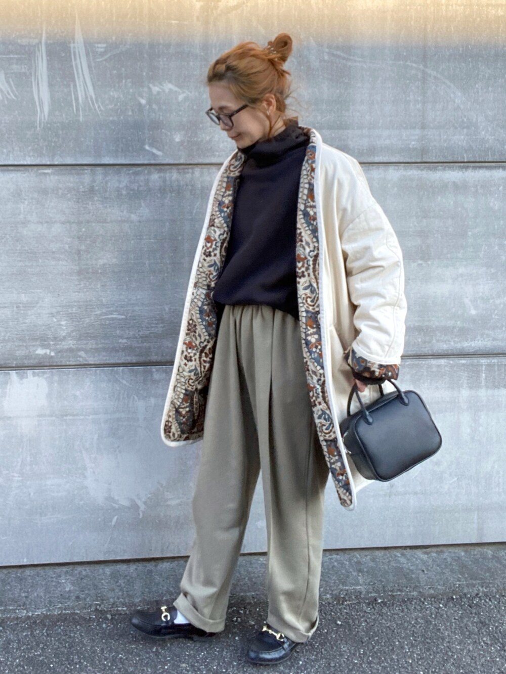 ブラック系のスウェット、ホワイト系のブルゾン、ブラック系のボストンバッグを着用したレディースの冬コーディネートの2枚目の写真