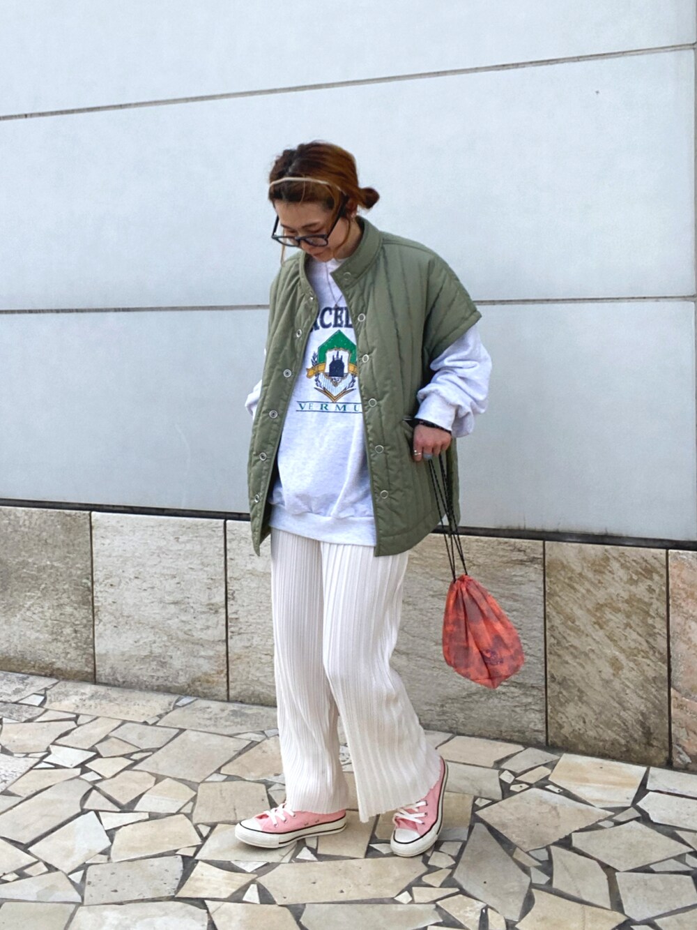 ホワイト系のその他パンツ、グリーン系のベスト、オレンジ系のショルダーバッグを着用したレディースの春コーディネートの2枚目の写真