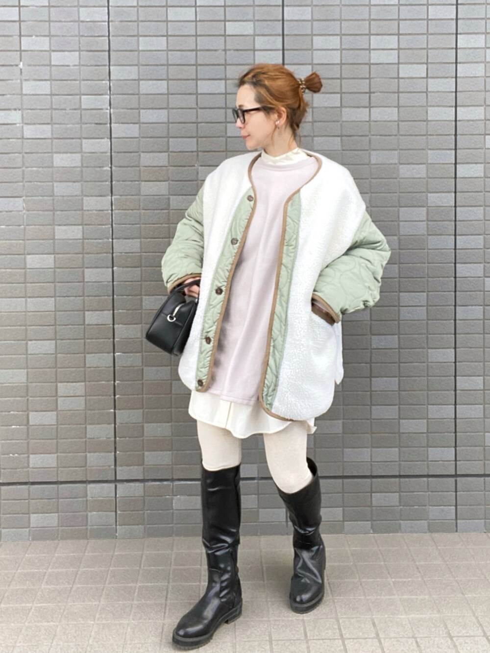 ホワイト系のノーカラージャケット、グレー系のスウェット、ブラック系のブーツを着用したレディースの冬コーディネートの2枚目の写真