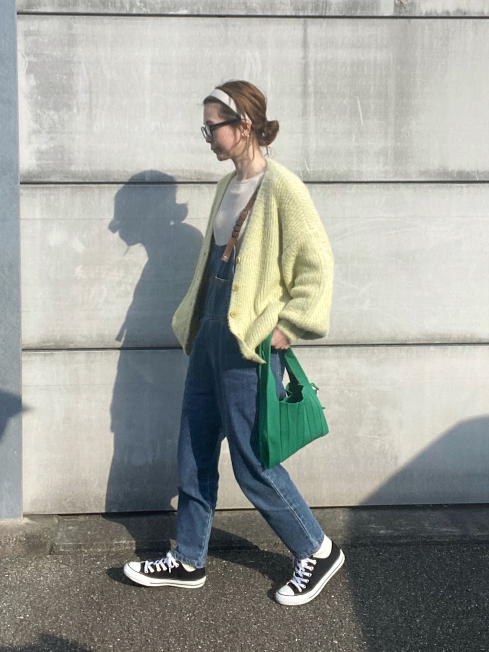 ベージュ系のニット/セーター、グリーン系のトートバッグ、ブラック系のスニーカーを着用したレディースの冬コーディネートの4枚目の写真