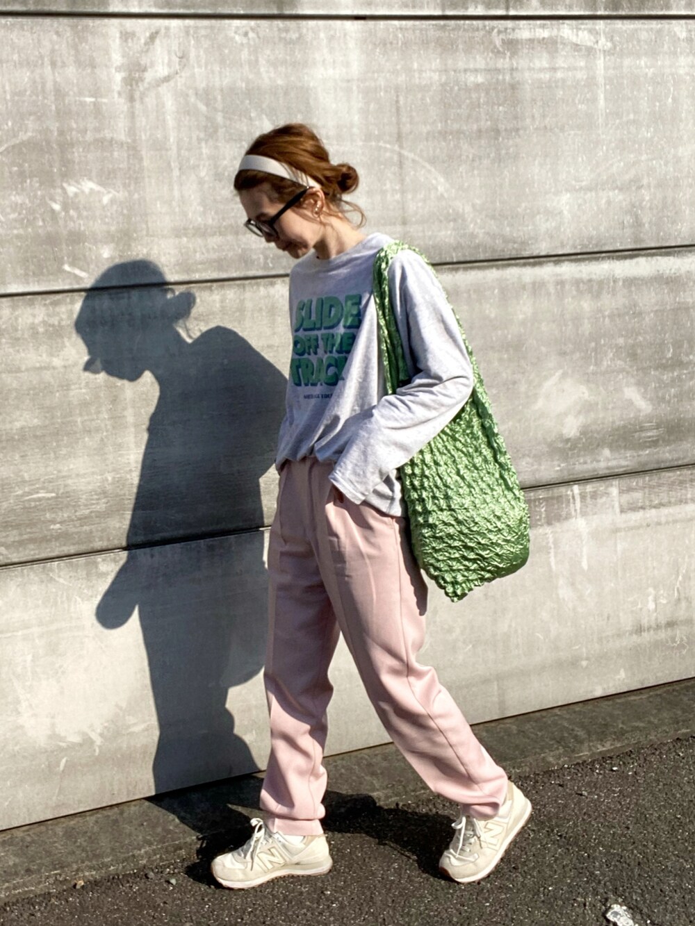 グレー系のTシャツ/カットソー、ピンク系のスラックス、ブルー系のトートバッグを着用したレディースの春コーディネートの3枚目の写真