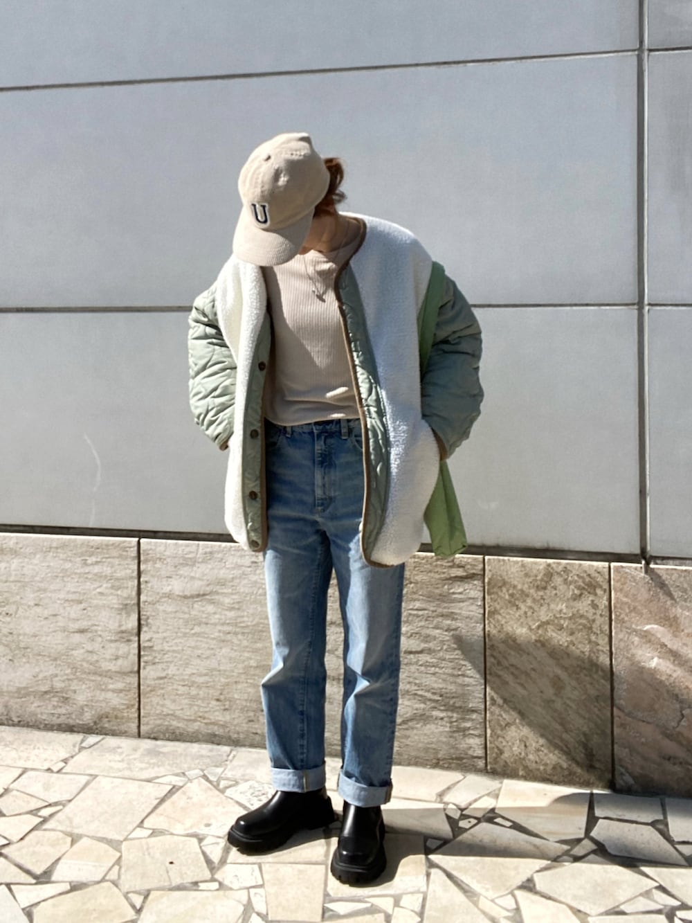 ベージュ系のニット/セーター、ブルー系のパンツ、ブラック系のブーツを着用したレディースの冬コーディネートの2枚目の写真