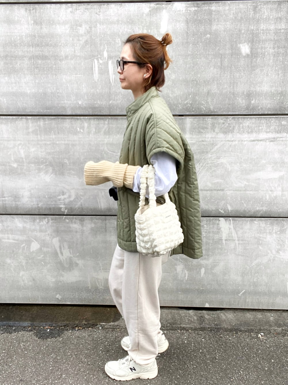 ホワイト系のTシャツ/カットソー、グリーン系のベスト、ホワイト系のスニーカーを着用したレディースの秋コーディネートの2枚目の写真