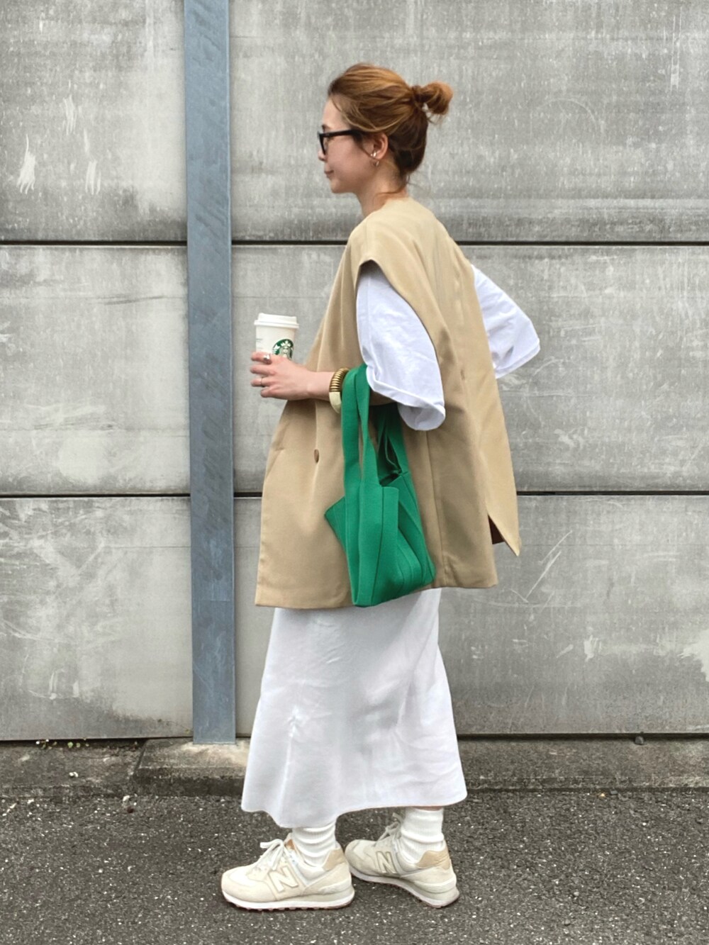 ベージュ系のベスト、ホワイト系のTシャツ/カットソー、ホワイト系のスカートを着用したレディースの春コーディネートの2枚目の写真