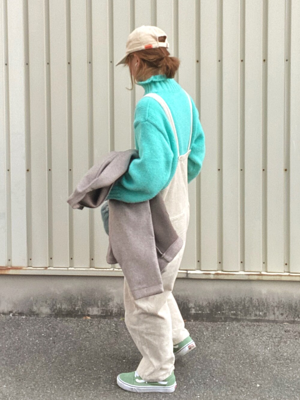 ブルー系のニット/セーター、ブルー系のショルダーバッグ、ベージュ系のつなぎ/オールインワンを着用したレディースの冬コーディネートの2枚目の写真