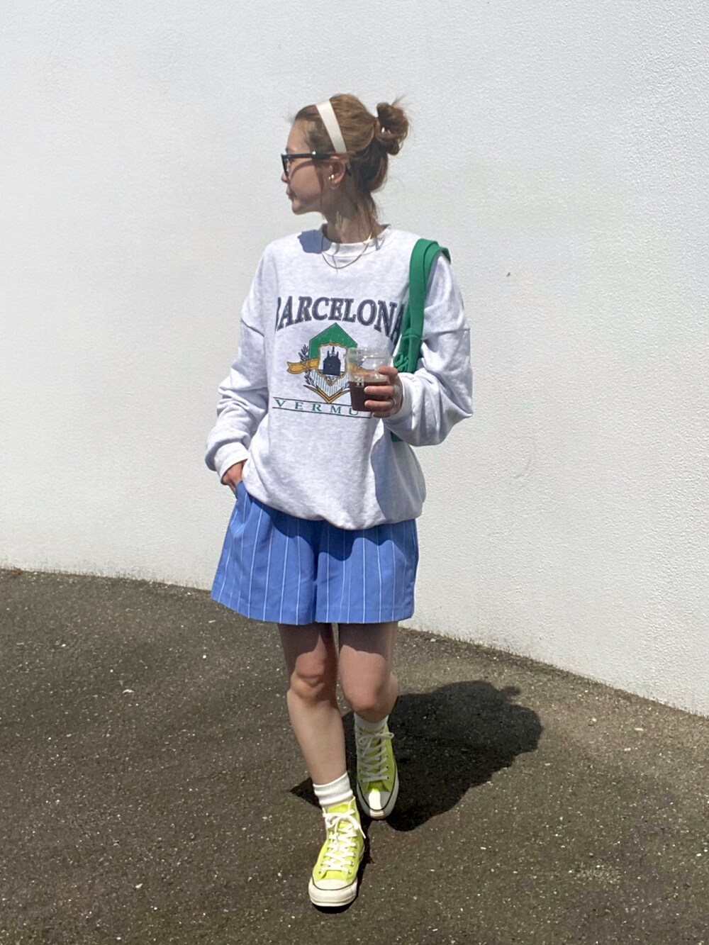 イエロー系のスニーカー、グリーン系のトートバッグを着用したレディースの春コーディネートの3枚目の写真