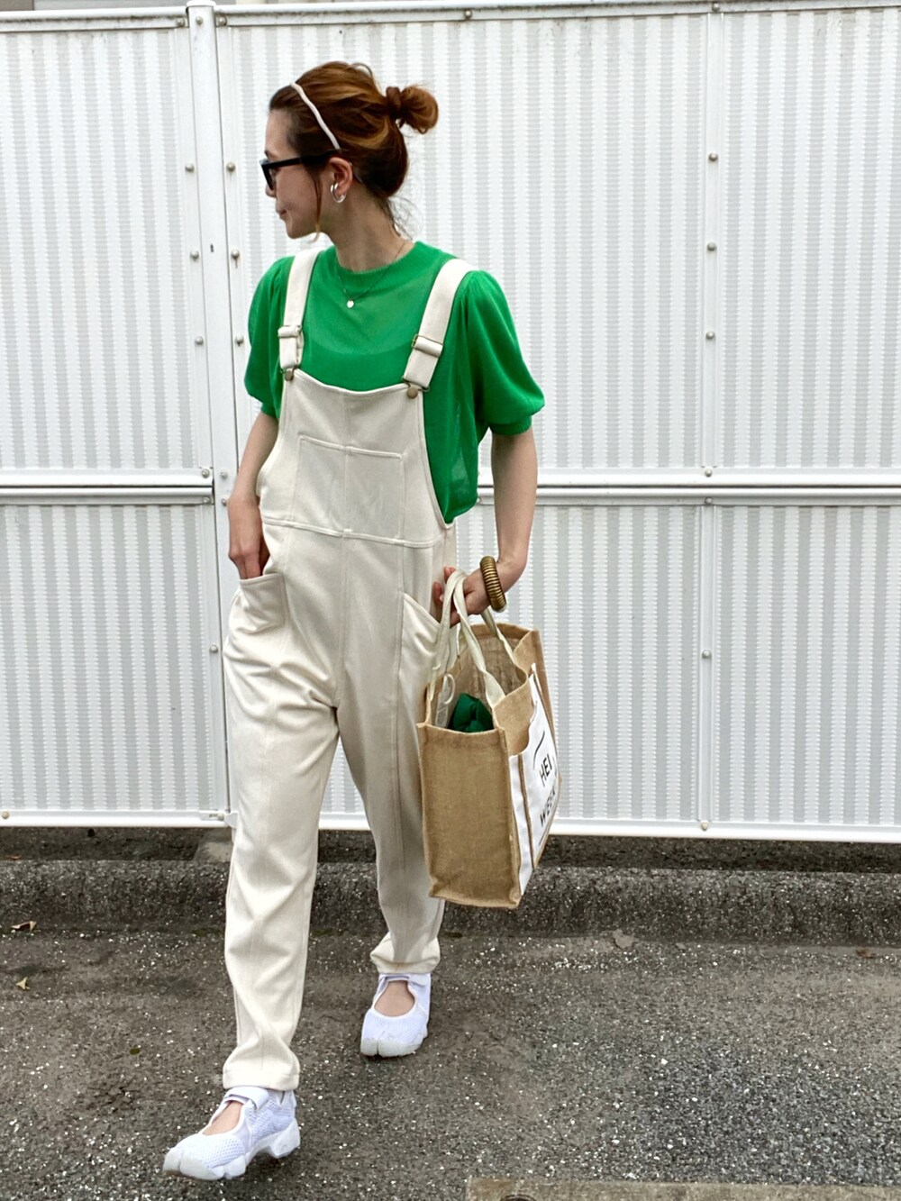 グリーン系のニット/セーター、ホワイト系のサロペット/オーバーオール、ホワイト系のサンダルを着用したレディースの夏コーディネートの3枚目の写真