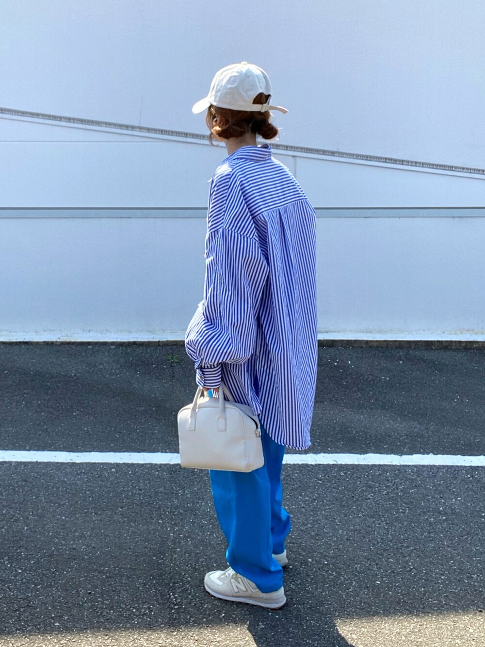 ブルー系のシャツ/ブラウス、ブルー系のスラックス、ホワイト系のボストンバッグを着用したレディースの春コーディネートの3枚目の写真