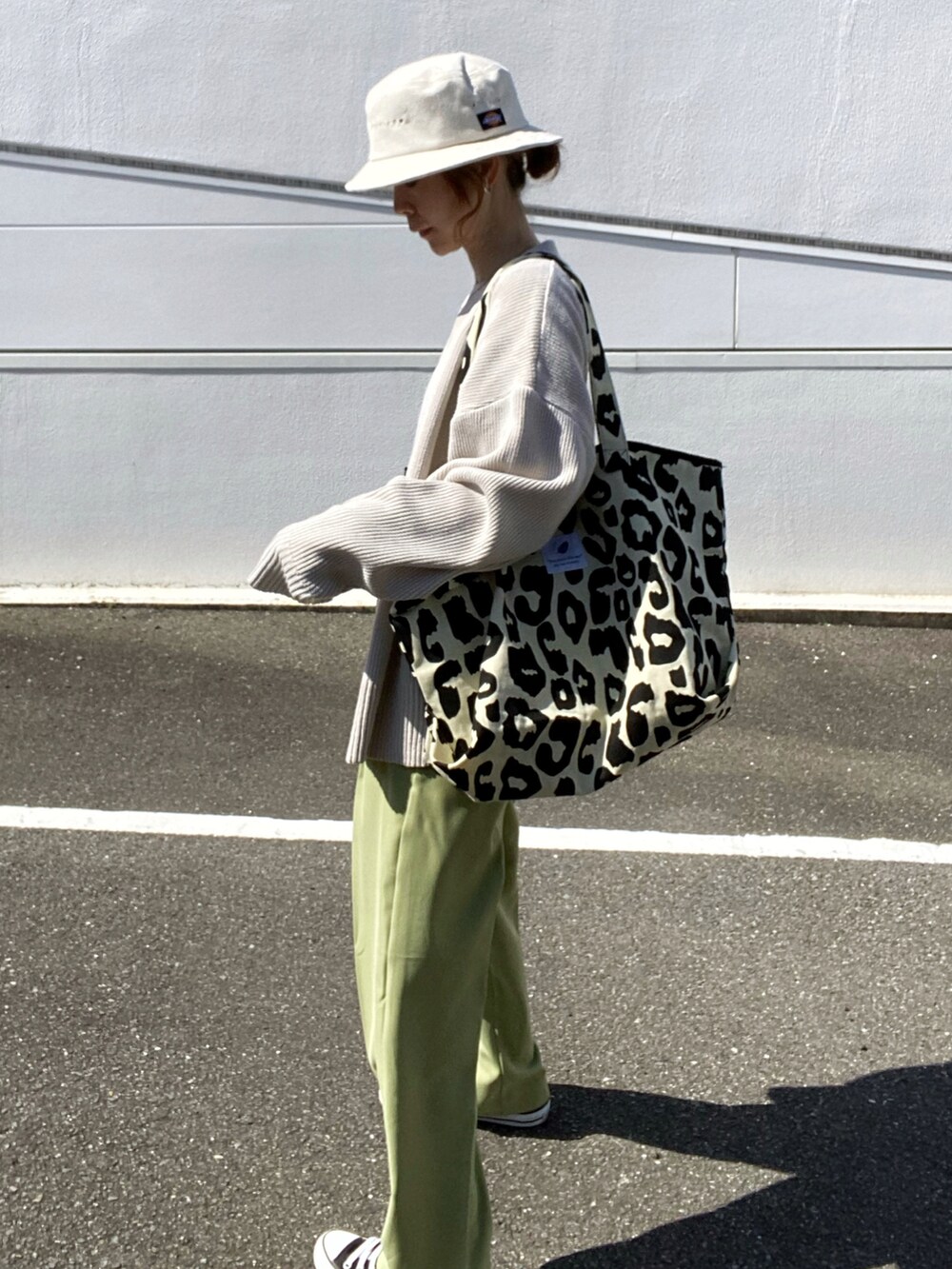 ベージュ系のニット/セーター、グリーン系のその他パンツ、ブラック系のトートバッグを着用したレディースの春コーディネートの2枚目の写真