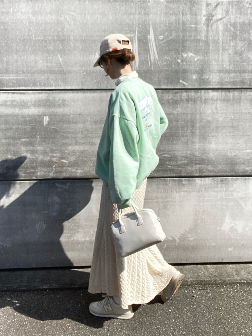 ホワイト系のスカート、ホワイト系のボストンバッグ、ホワイト系のスニーカーを着用したレディースの冬コーディネートの2枚目の写真