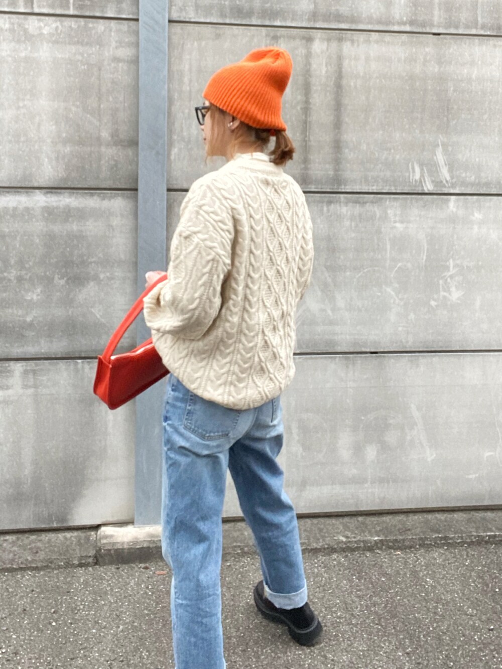 ホワイト系のニット/セーター、オレンジ系のショルダーバッグ、ブラック系のブーツを着用したレディースの冬コーディネートの3枚目の写真