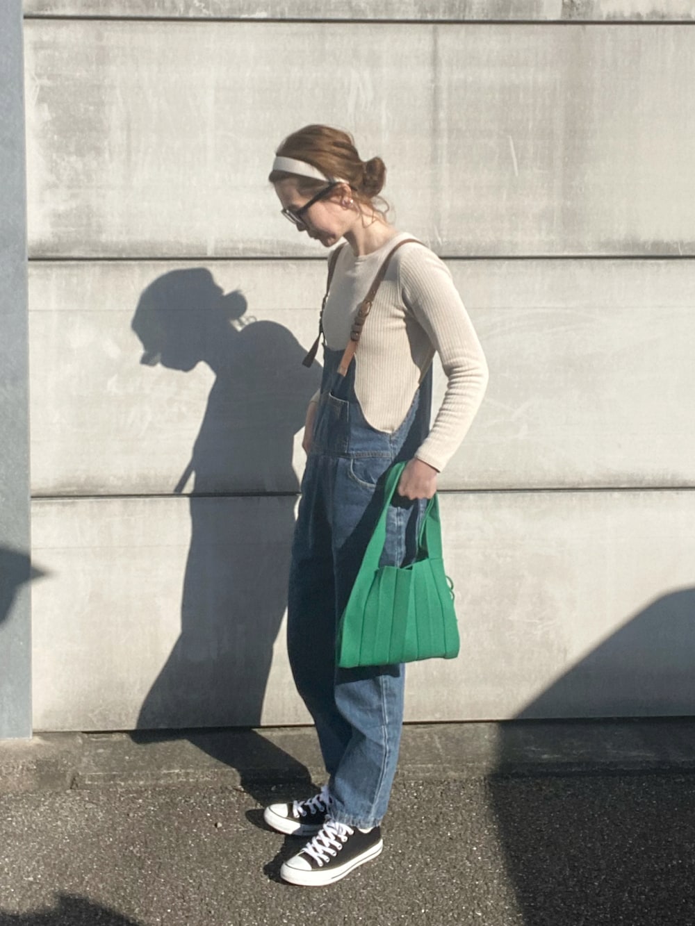 ベージュ系のニット/セーター、グリーン系のトートバッグ、ブラック系のスニーカーを着用したレディースの冬コーディネートの2枚目の写真