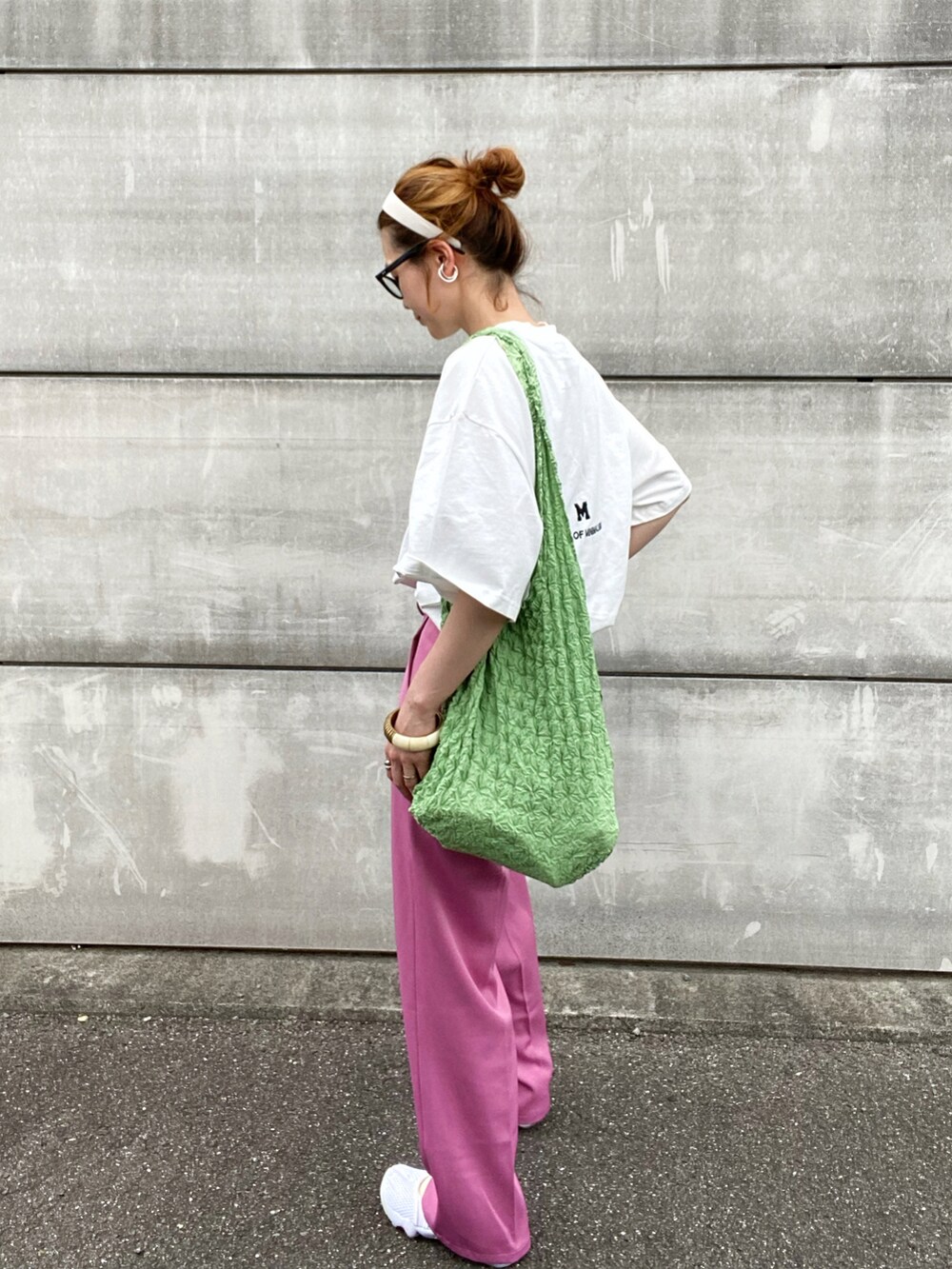 ピンク系のスラックス、ホワイト系のサンダル、ブルー系のトートバッグを着用したレディースの夏コーディネートの2枚目の写真