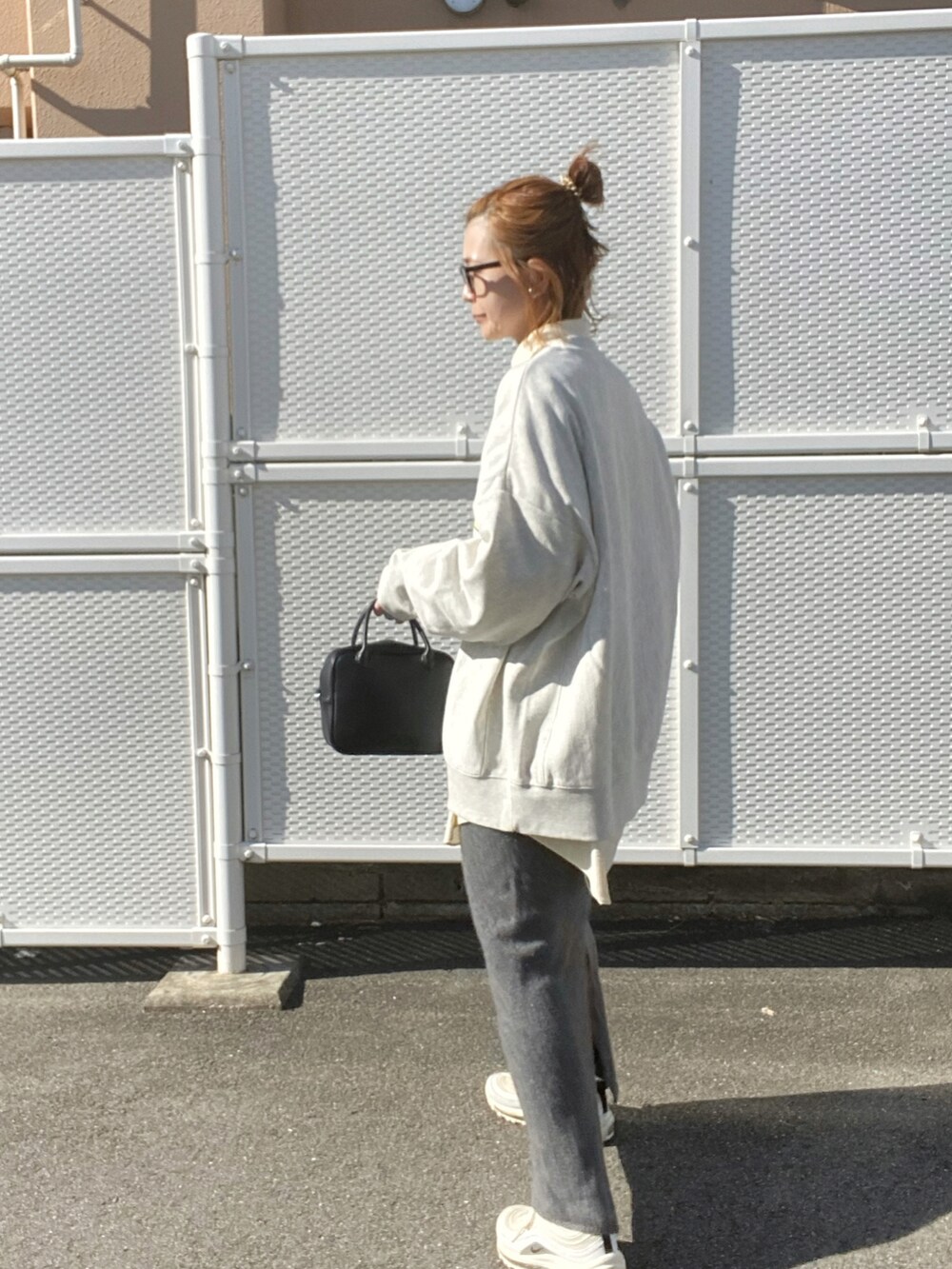 ブラック系のボストンバッグ、ベージュ系のスウェット、ホワイト系のスニーカーを着用したレディースの冬コーディネートの3枚目の写真