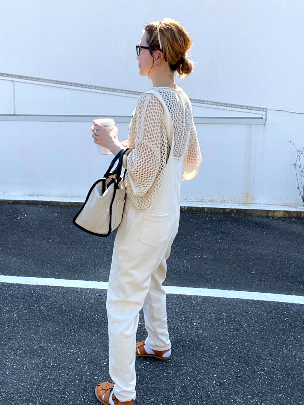 ホワイト系のニット/セーター、ピンク系のタンクトップ、ホワイト系のサロペット/オーバーオールを着用したレディースの夏コーディネートの2枚目の写真