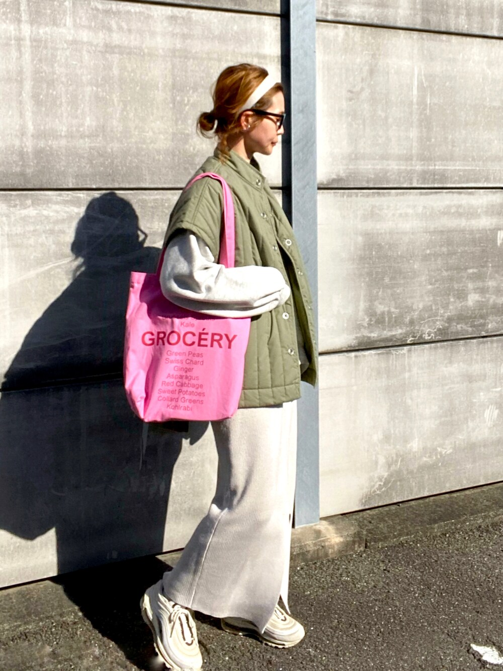 グリーン系のベスト、ベージュ系のスウェット、ホワイト系のスカートを着用したレディースの春コーディネートの2枚目の写真