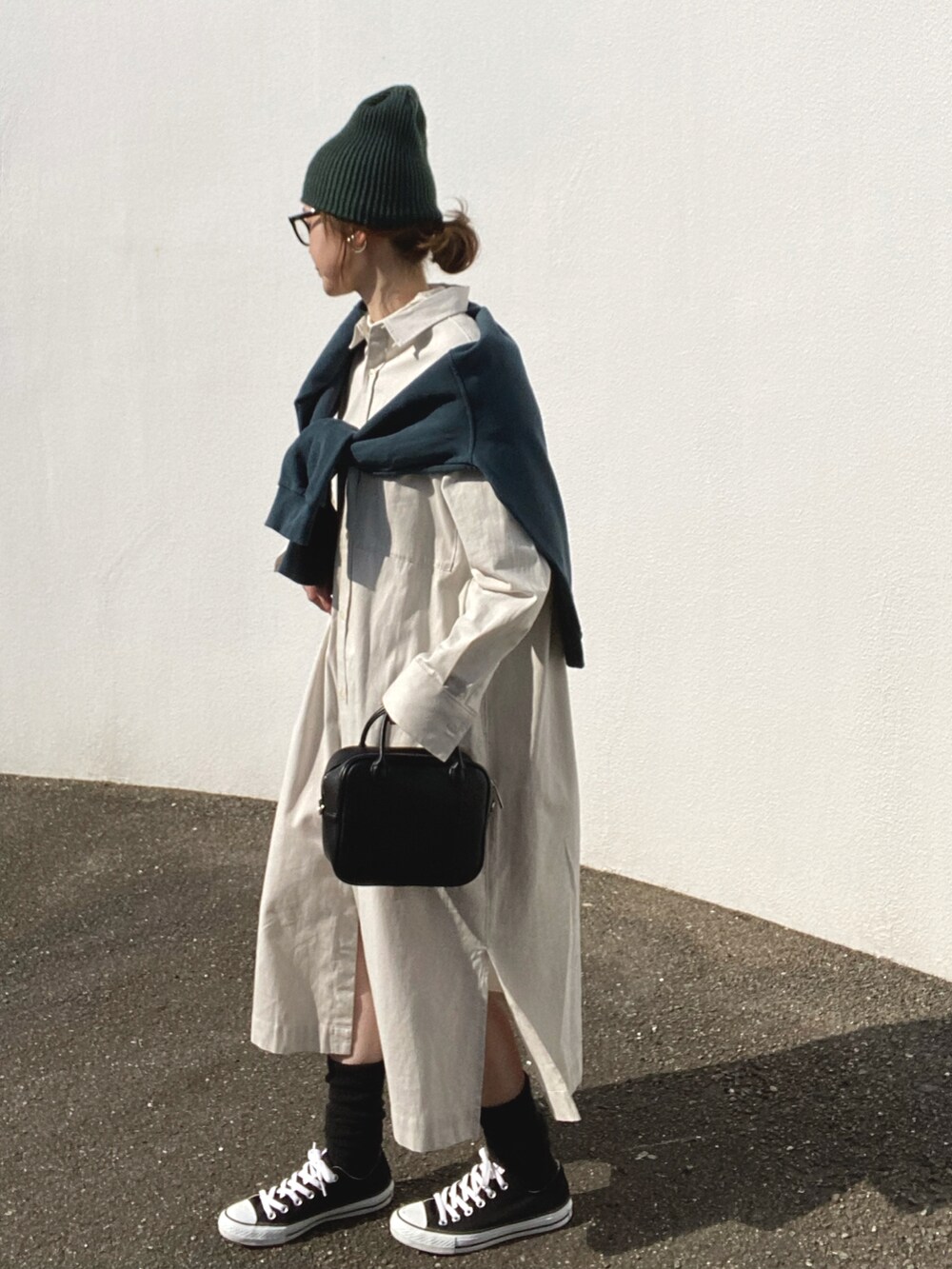 ベージュ系のワンピース、ブラック系のボストンバッグ、ブラック系のスニーカーを着用したレディースの冬コーディネートの2枚目の写真