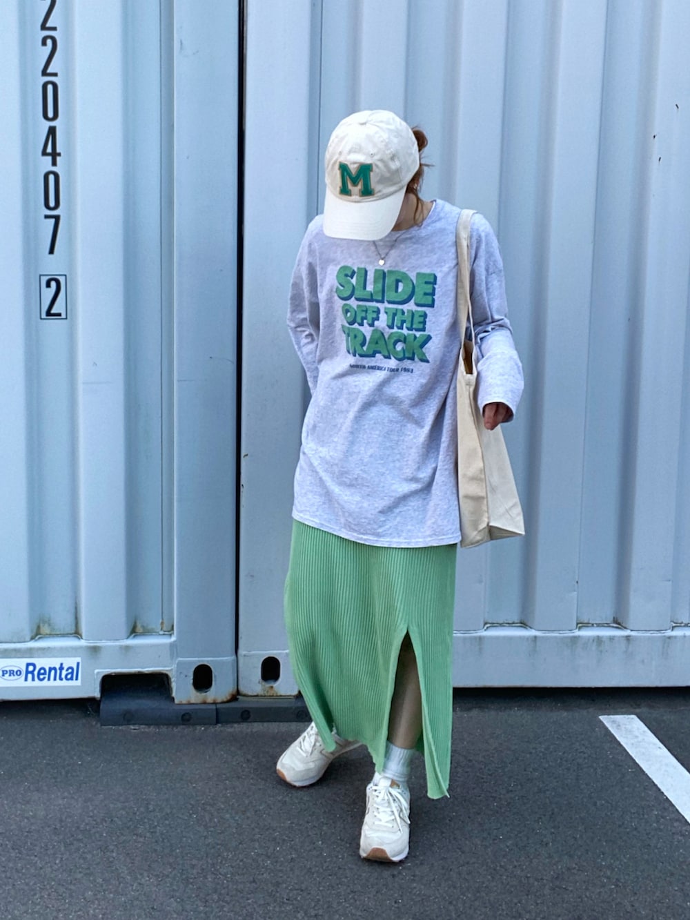 ホワイト系のエコバッグ/サブバッグ、グレー系のTシャツ/カットソー、グリーン系のスカートを着用したレディースの春コーディネートの2枚目の写真