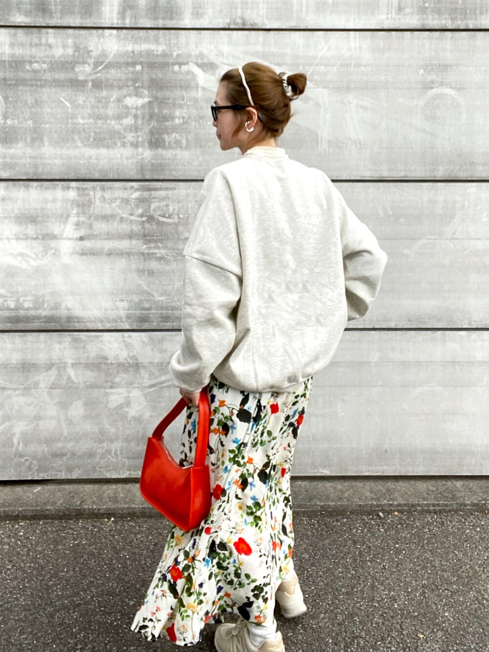 ホワイト系のスカート、オレンジ系のショルダーバッグ、ホワイト系のスニーカーを着用したレディースの冬コーディネートの2枚目の写真