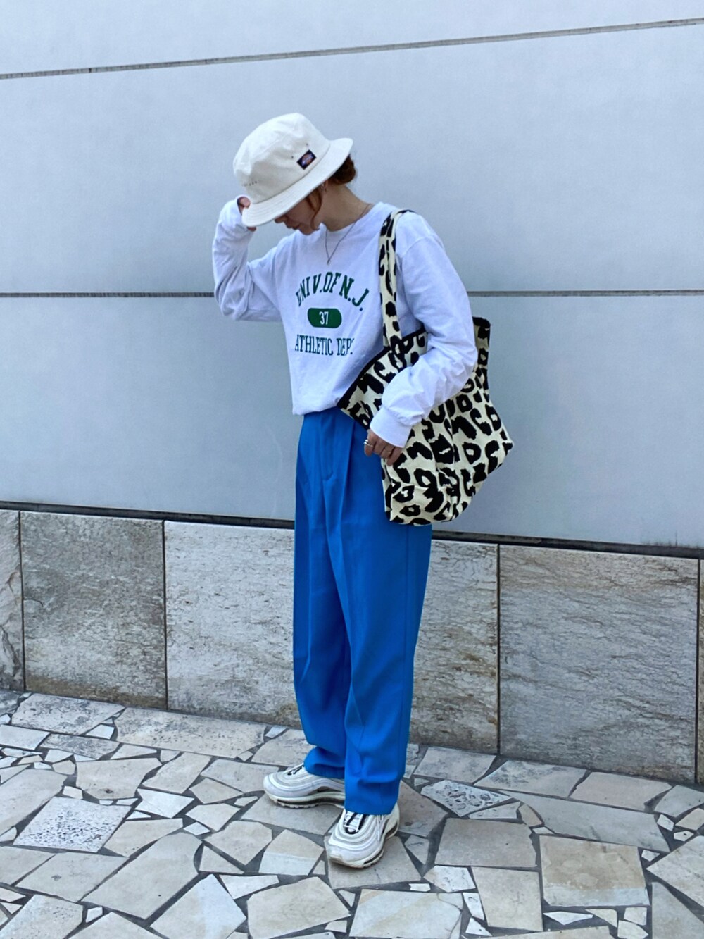 ホワイト系のTシャツ/カットソー、ブルー系のスラックス、ホワイト系のスニーカーを着用したレディースの春コーディネートの2枚目の写真