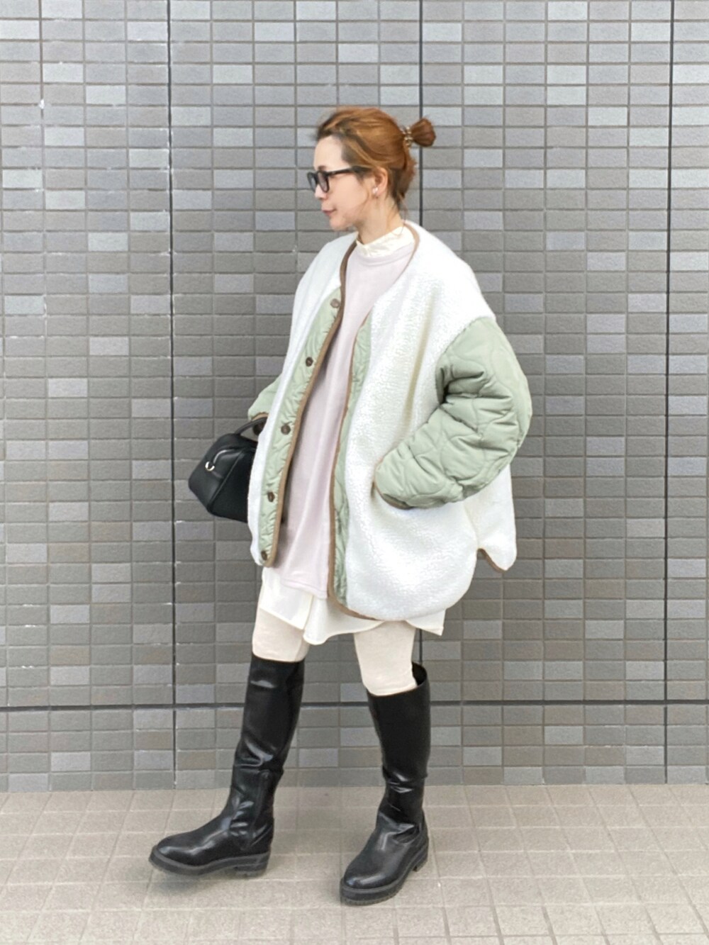 ホワイト系のノーカラージャケット、グレー系のスウェット、ブラック系のブーツを着用したレディースの冬コーディネートの3枚目の写真