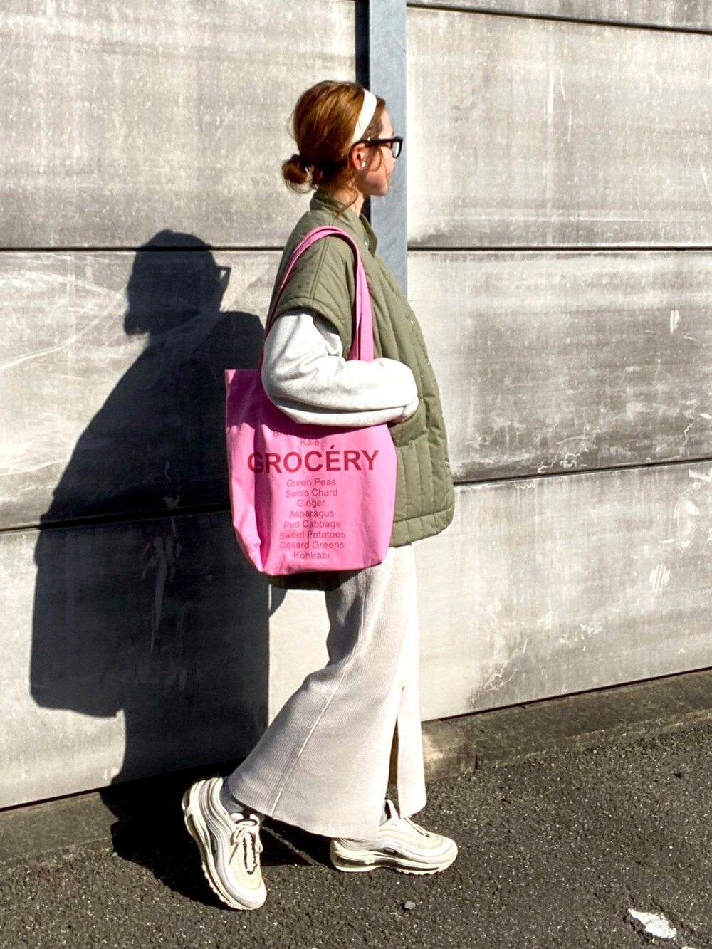 グリーン系のベスト、ベージュ系のスウェット、ホワイト系のスカートを着用したレディースの春コーディネートの3枚目の写真