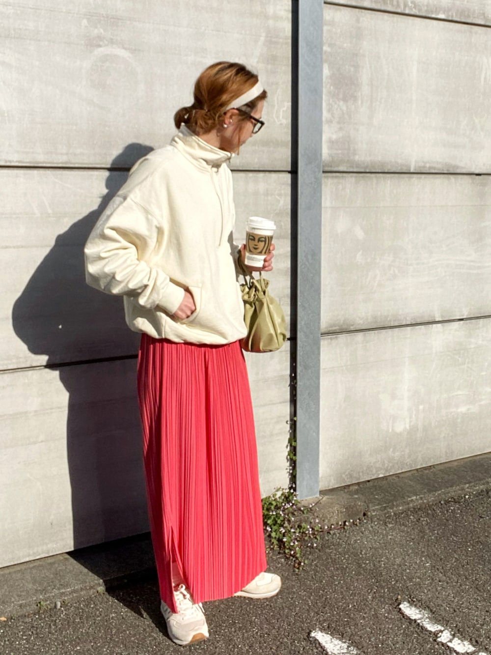 ピンク系のスカート、ホワイト系のスウェット、ホワイト系のスニーカーを着用したレディースの春コーディネートの2枚目の写真