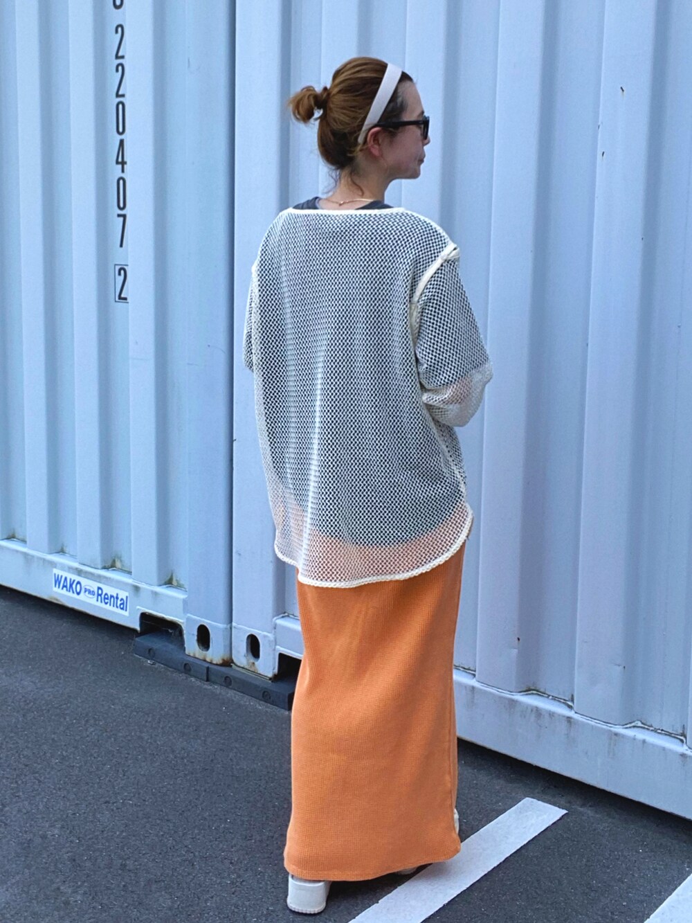 ホワイト系のTシャツ/カットソー、オレンジ系のスカート、ベージュ系のサンダルを着用したレディースの夏コーディネートの3枚目の写真