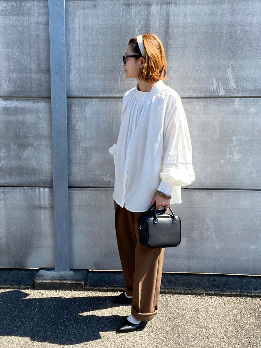 ホワイト系のシャツ/ブラウス、ブラック系のパンプス、ブラック系のボストンバッグを着用したレディースの秋コーディネートの3枚目の写真