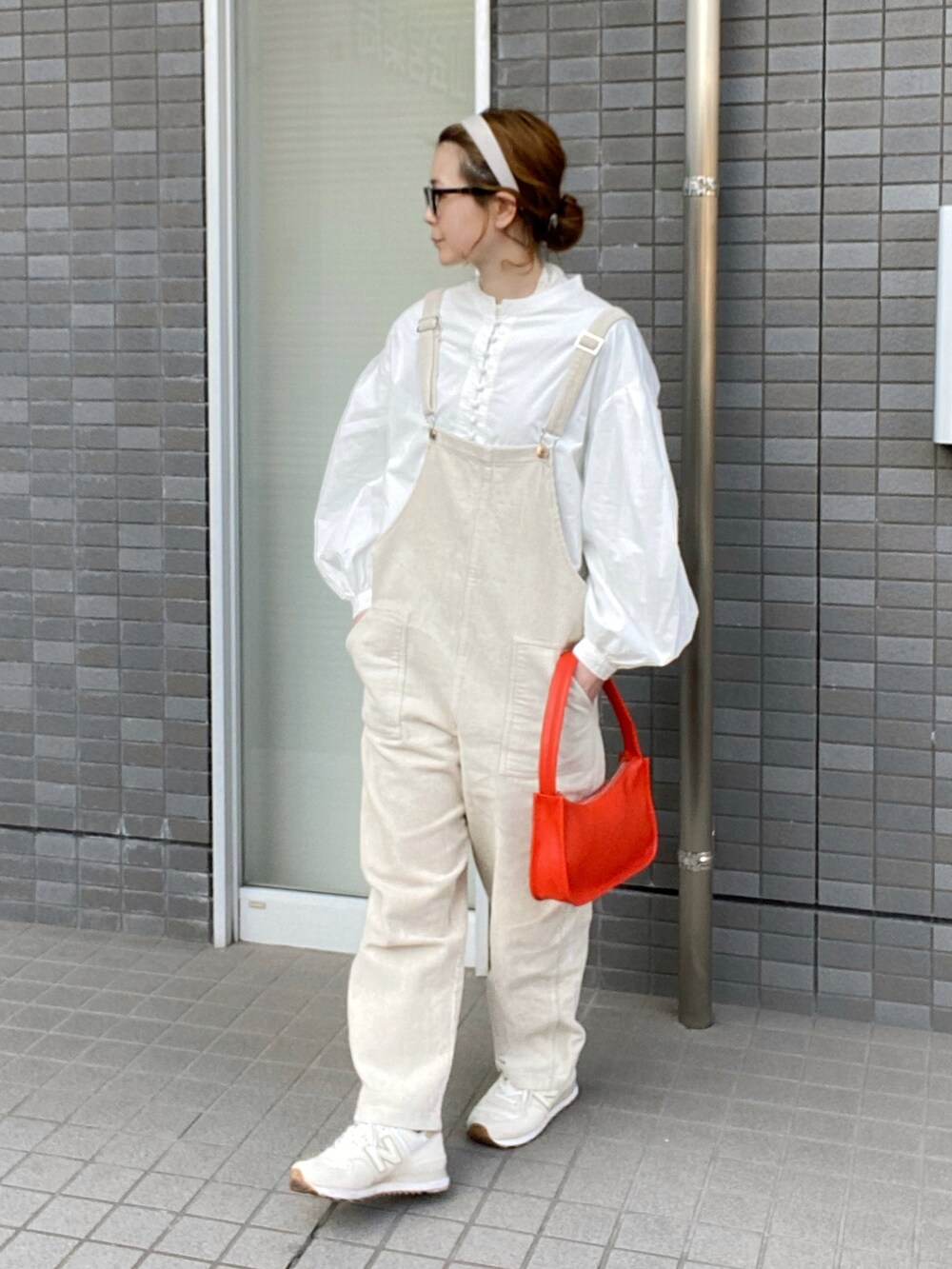 ホワイト系のシャツ/ブラウス、ベージュ系のつなぎ/オールインワン、オレンジ系のショルダーバッグを着用したレディースの冬コーディネートの3枚目の写真