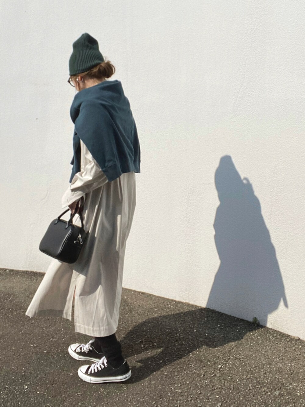 ベージュ系のワンピース、ブラック系のボストンバッグ、ブラック系のスニーカーを着用したレディースの冬コーディネートの3枚目の写真