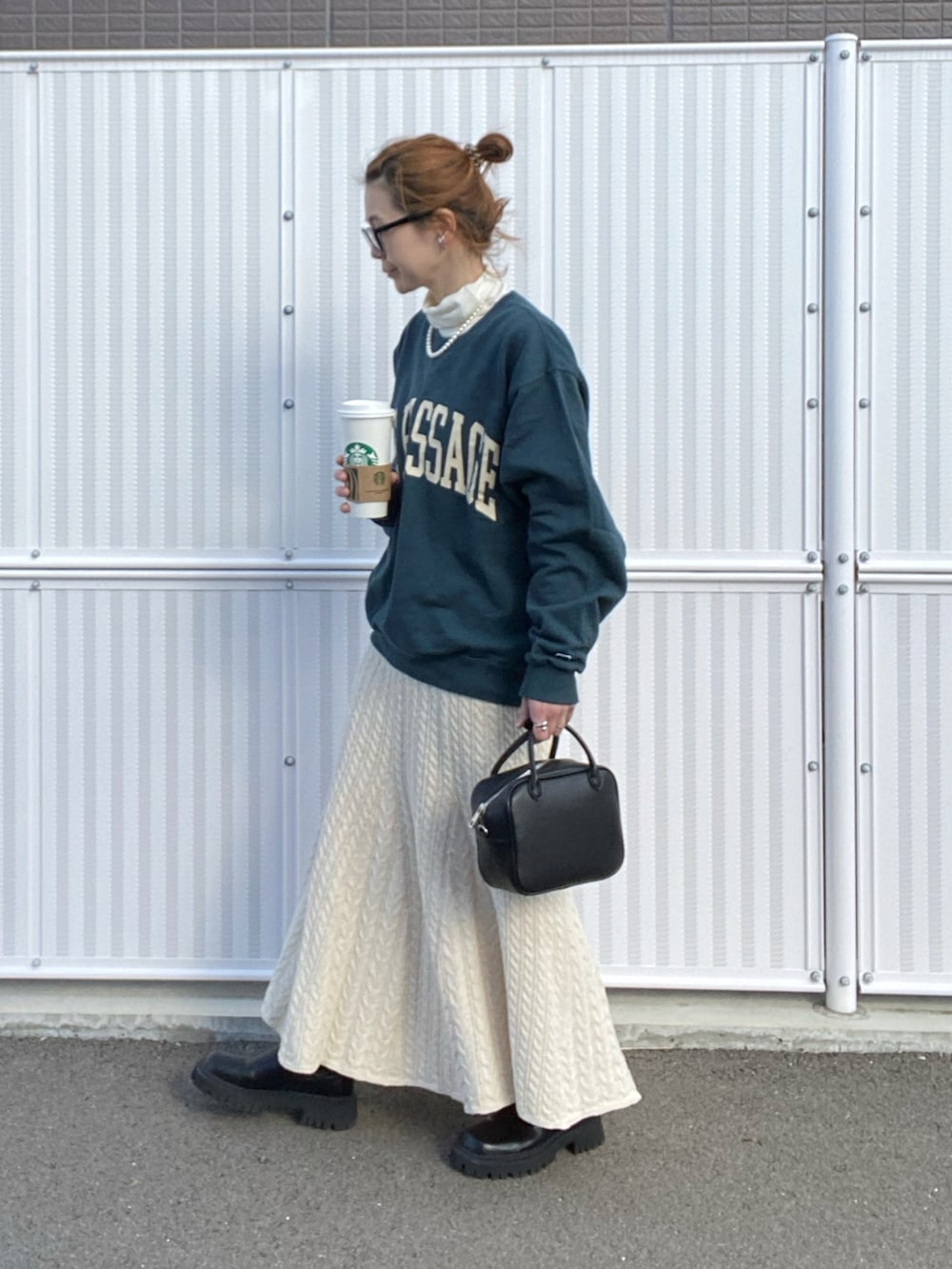 ホワイト系のスカート、グリーン系のスウェット、ブラック系のボストンバッグを着用したレディースの冬コーディネートの3枚目の写真