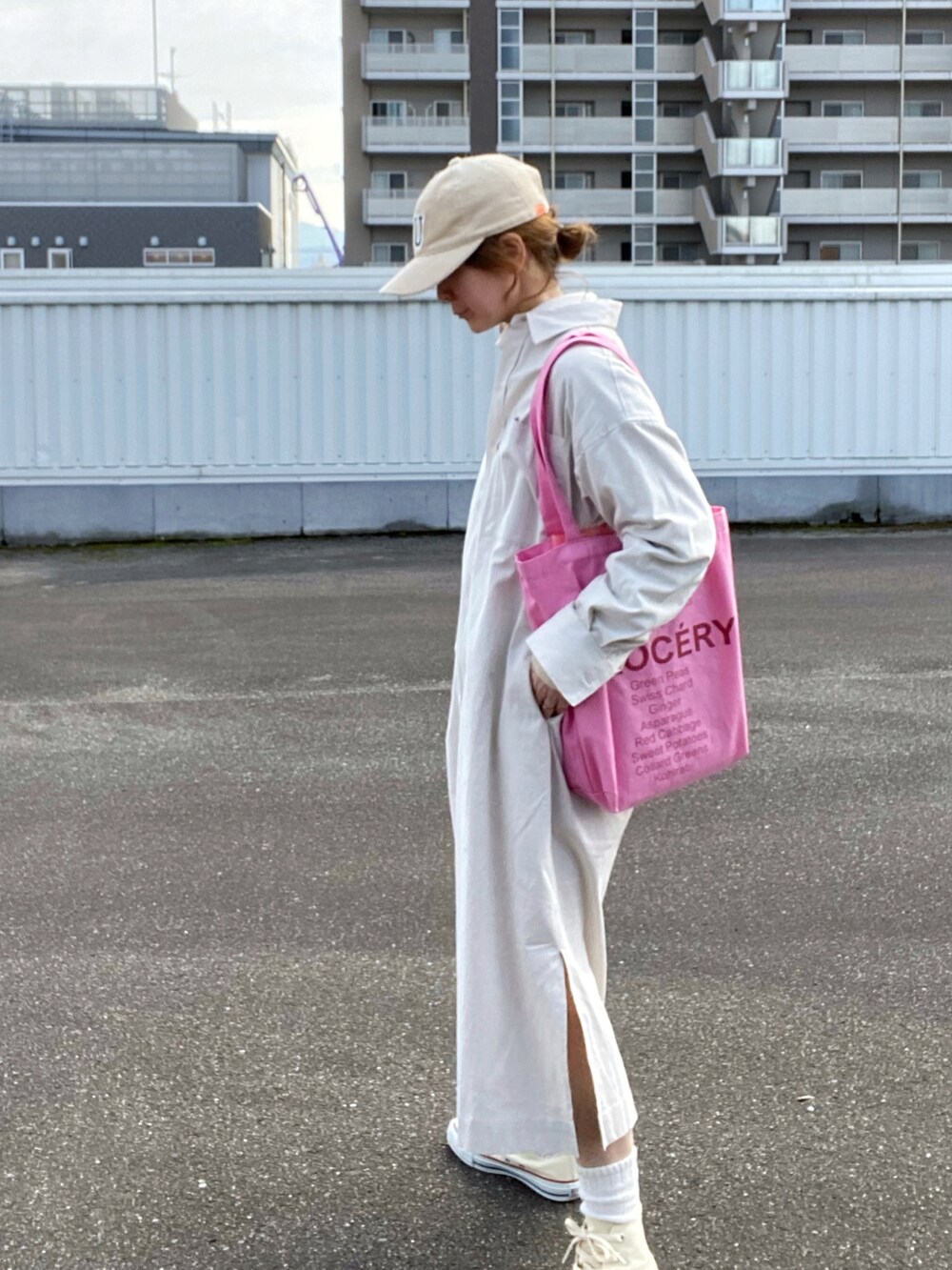 ベージュ系のワンピース、ホワイト系のスニーカー、ピンク系のトートバッグを着用したレディースの冬コーディネートの3枚目の写真