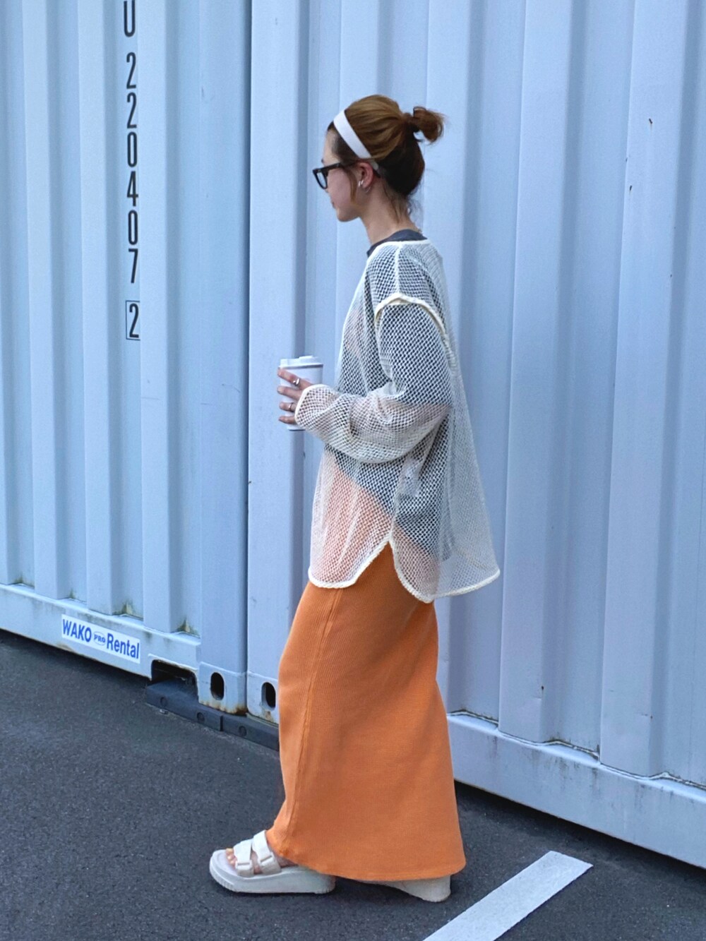 ホワイト系のTシャツ/カットソー、オレンジ系のスカート、ベージュ系のサンダルを着用したレディースの夏コーディネートの2枚目の写真