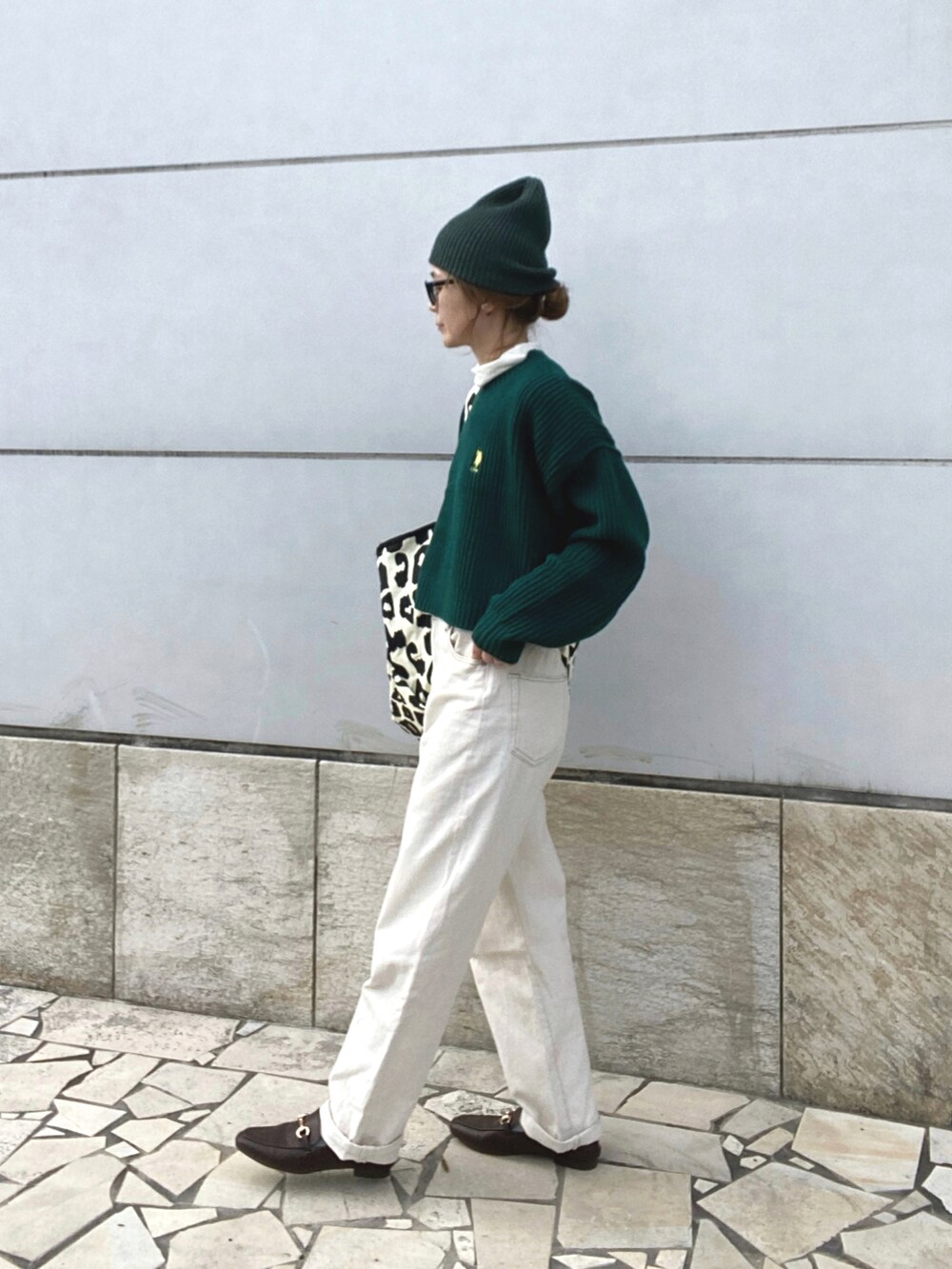 グリーン系のニット/セーター、ホワイト系のデニムパンツ、ブラウン系のローファーを着用したレディースの冬コーディネートの3枚目の写真