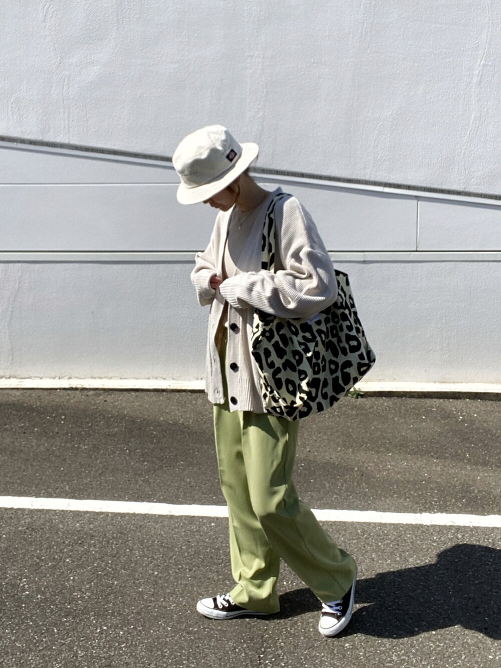 ベージュ系のニット/セーター、グリーン系のその他パンツ、ブラック系のトートバッグを着用したレディースの春コーディネートの3枚目の写真