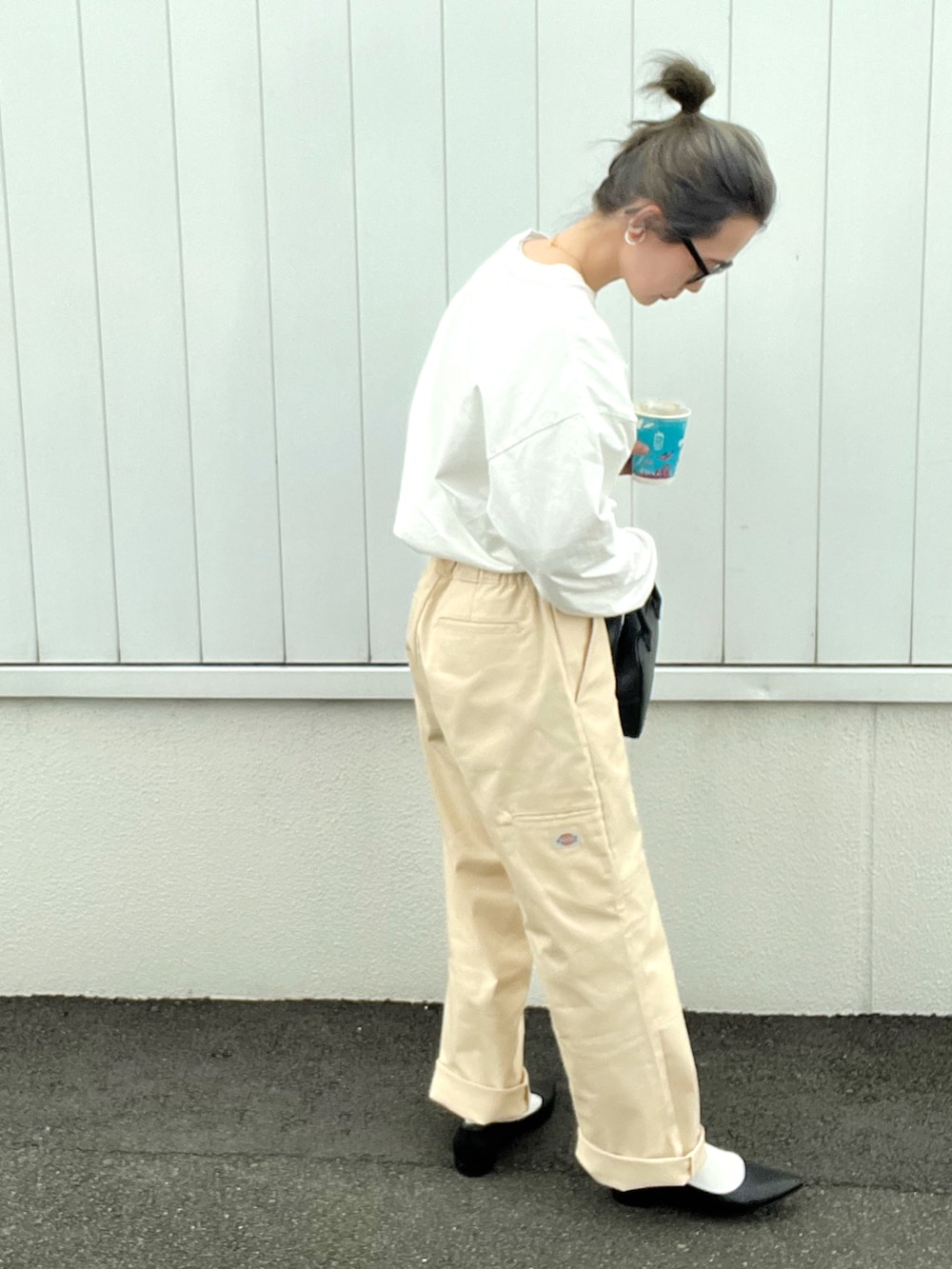 ベージュ系のチノパンツ、ブラック系のTシャツ/カットソー、ブラック系のパンプスを着用したレディースの春コーディネートの2枚目の写真