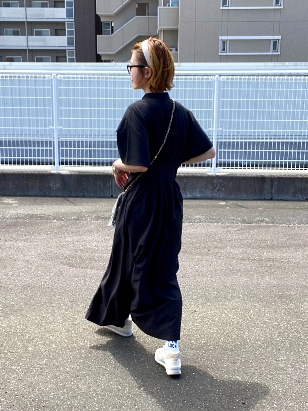 ブラック系のワンピース、ホワイト系のスニーカーを着用したレディースの秋コーディネートの2枚目の写真