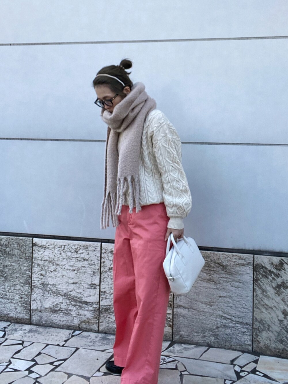 ピンク系のチノパンツ、ホワイト系のニット/セーター、ホワイト系のボストンバッグを着用したレディースの冬コーディネートの2枚目の写真