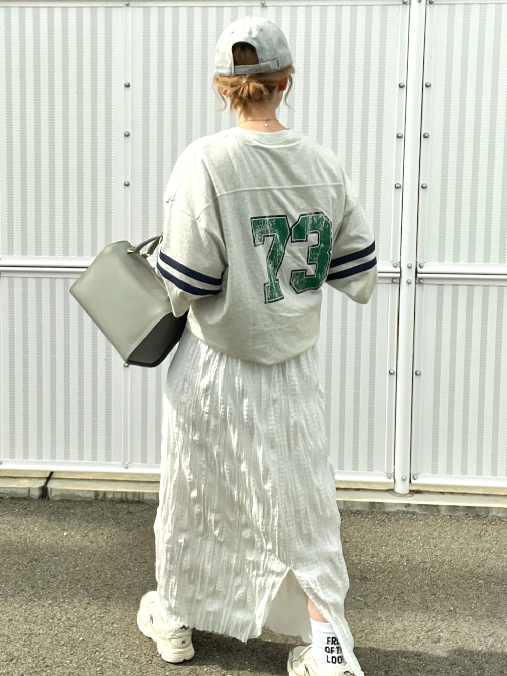 ベージュ系のTシャツ/カットソー、ホワイト系のスカート、ホワイト系のスニーカーを着用したレディースの夏コーディネートの3枚目の写真