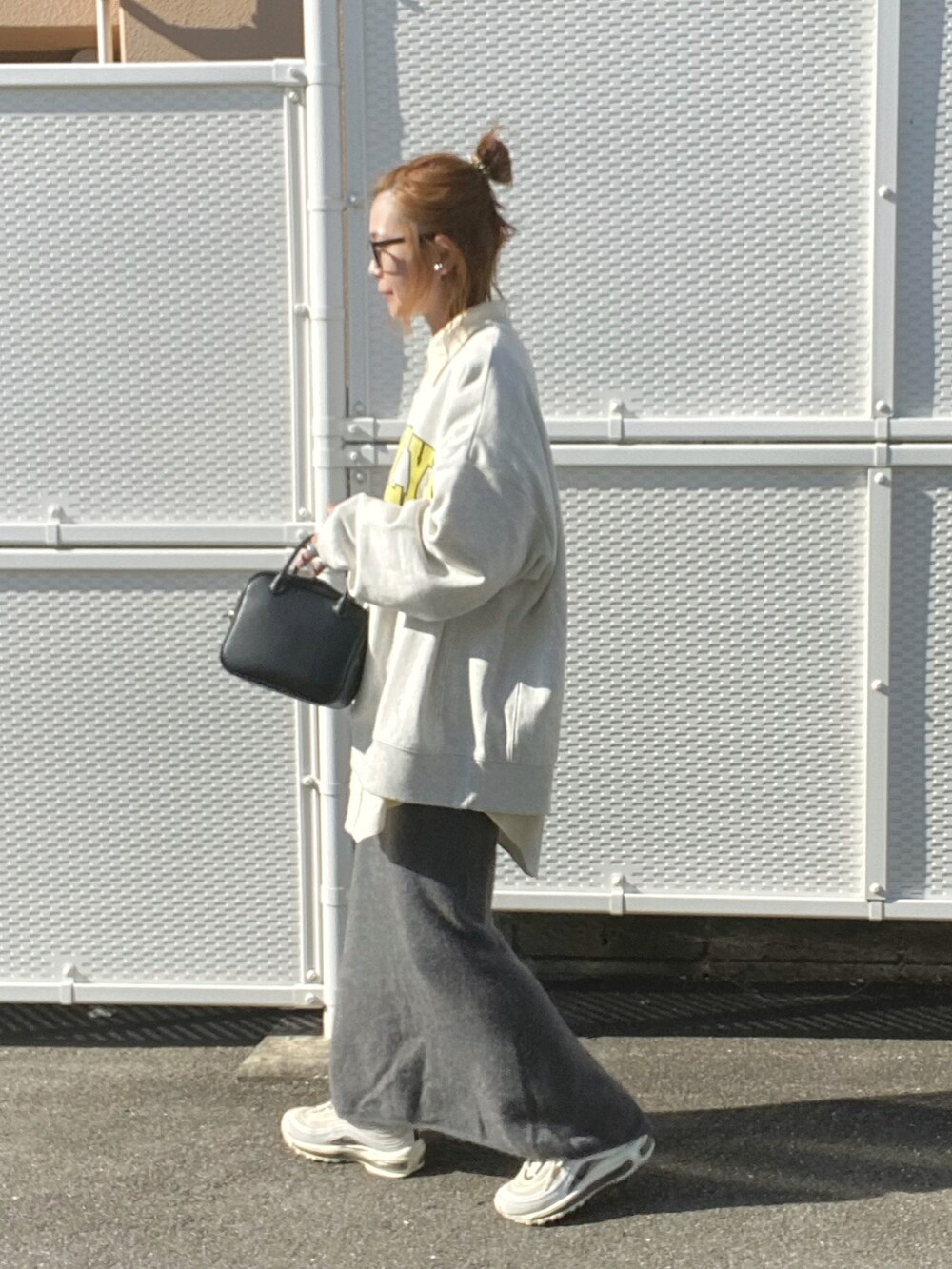 ブラック系のボストンバッグ、ベージュ系のスウェット、ホワイト系のスニーカーを着用したレディースの冬コーディネートの2枚目の写真