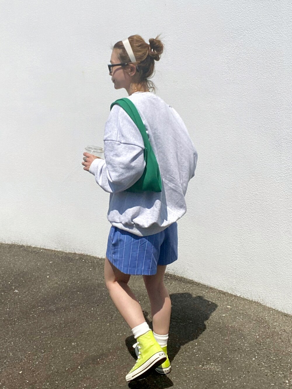 イエロー系のスニーカー、グリーン系のトートバッグを着用したレディースの春コーディネートの2枚目の写真