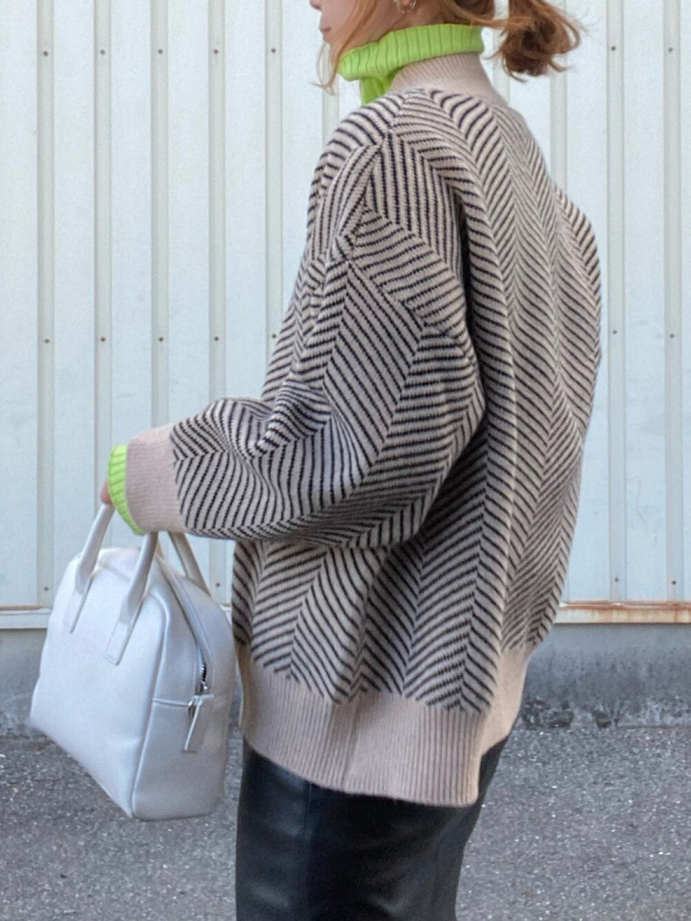 ブラック系のカーディガン/ボレロ、グリーン系のニット/セーター、ブラック系のスカートを着用したレディースの冬コーディネートの3枚目の写真