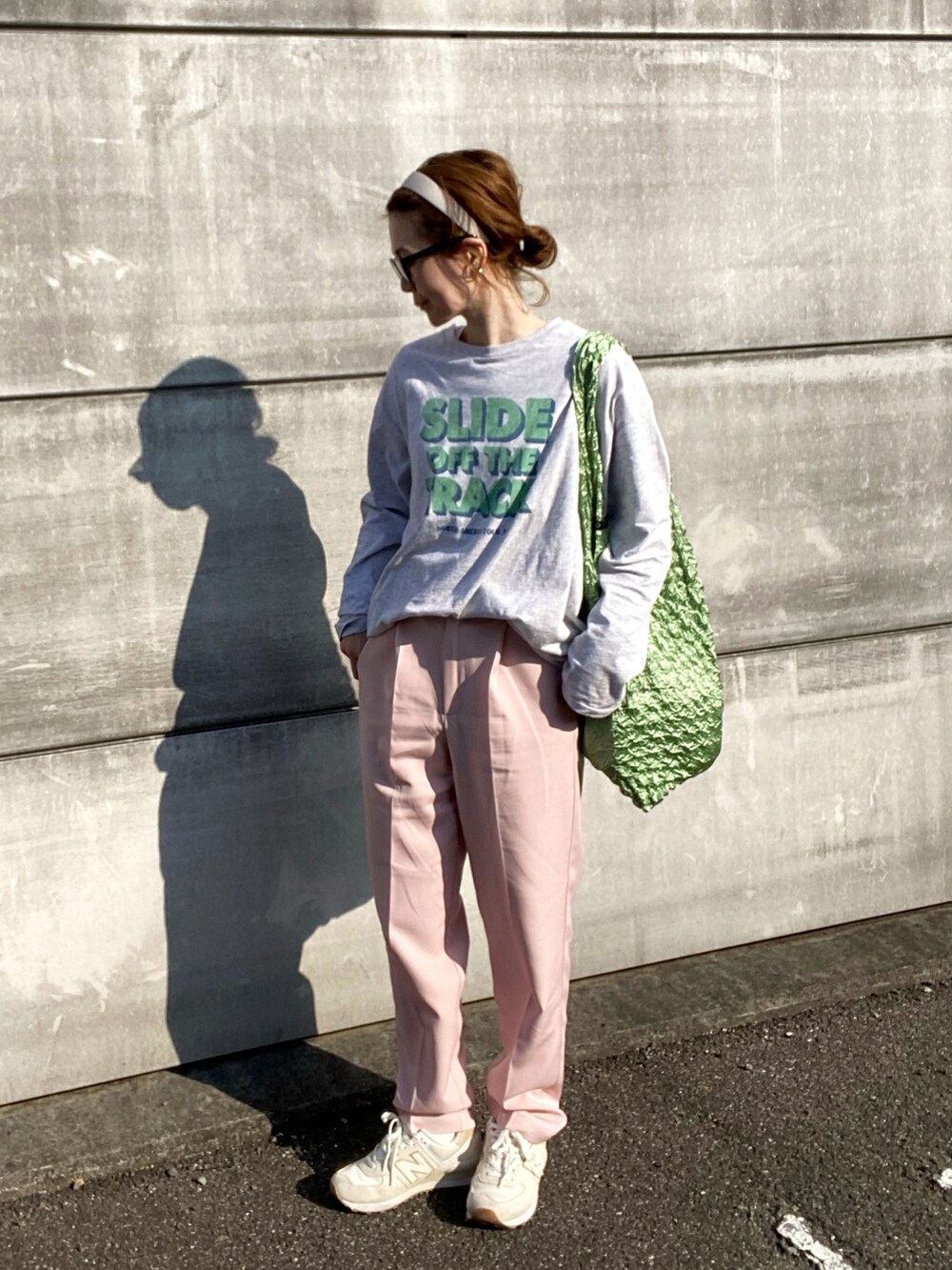 グレー系のTシャツ/カットソー、ピンク系のスラックス、ブルー系のトートバッグを着用したレディースの春コーディネートの2枚目の写真