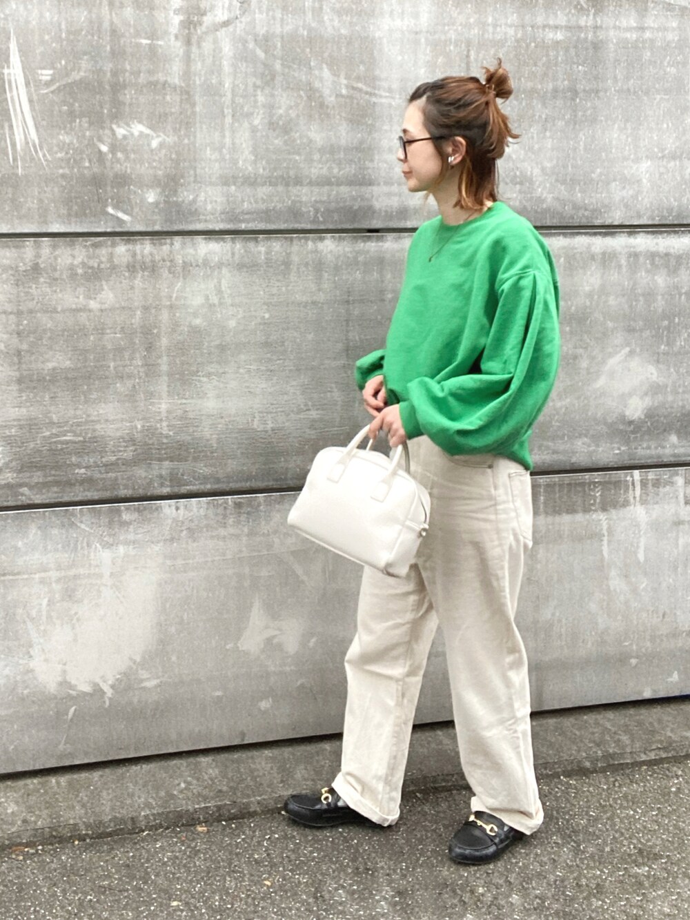 グリーン系のスウェット、ホワイト系のデニムパンツ、ホワイト系のボストンバッグを着用したレディースの秋コーディネートの3枚目の写真