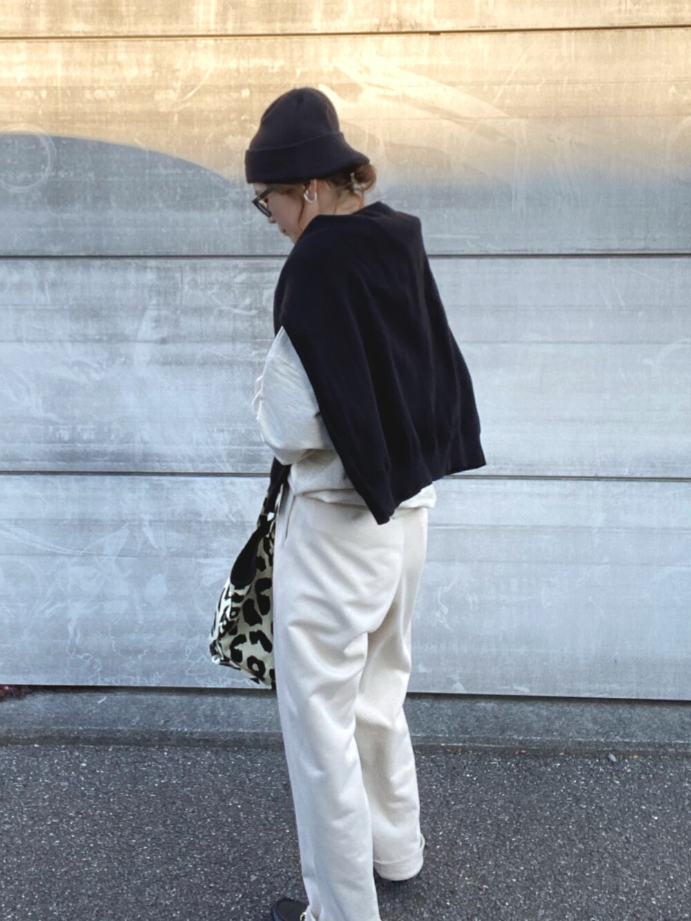 ベージュ系のスウェット、ブラック系のトートバッグ、ブラック系のローファーを着用したレディースの冬コーディネートの3枚目の写真